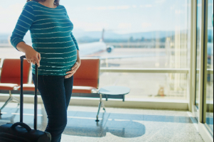 Embarazada con su maleta en el aeropuerto